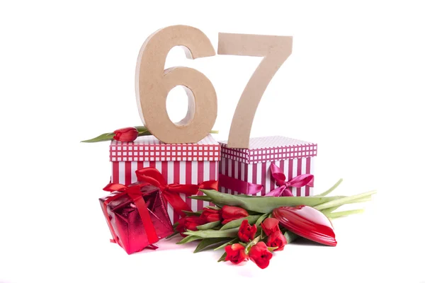 Ålder i siffror på partyhumör på en bädd av Röda tulpaner — Stockfoto