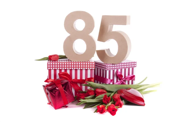 Age in figures in a party mood on a bed of red tulips — Stock Photo, Image