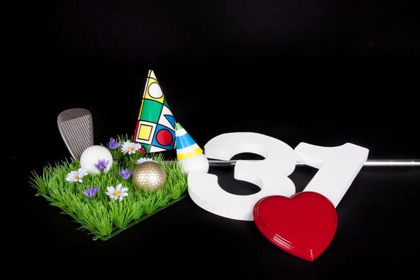 Een golf club en golf ball op een kunstmatige vrede van gras te worden gebruikt als een verjaardagskaart — Stockfoto