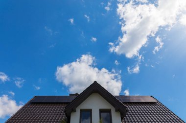 Solar panels on the house roof in sunny day. Renewable clean green energy generation.
