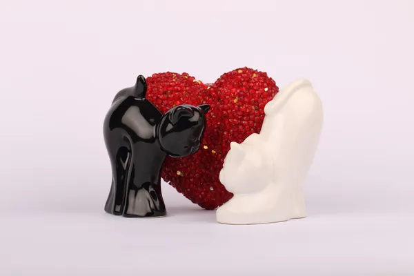 Chat en céramique noir et blanc avec cœur rouge derrière — Photo