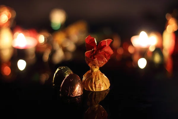 Chocolate candies and candles — Stock Photo, Image