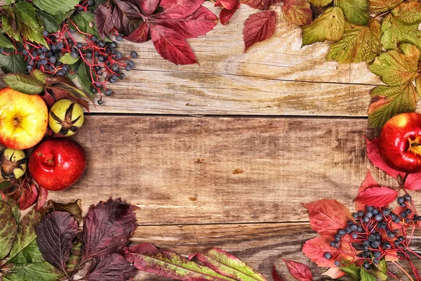 Autumn leaves and apples on old wood — Stock Photo, Image