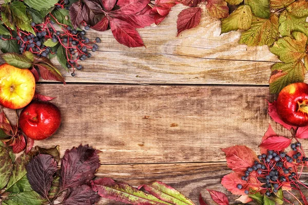 Feuilles d'automne et pommes sur vieux bois — Photo