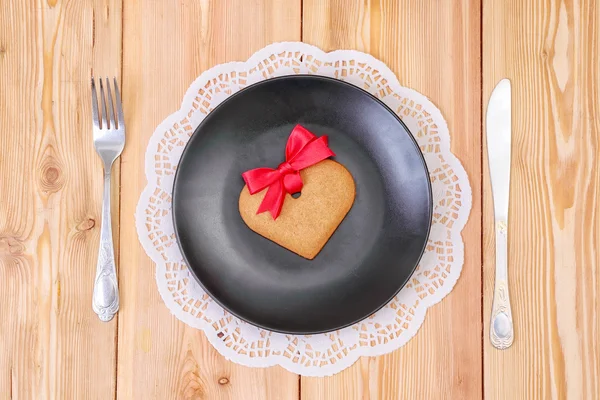 Heart shaped gingerbread cookie on the black plate — Stock Photo, Image