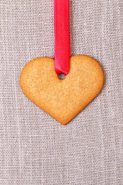 Biscoito de gengibre em forma de coração com fita vermelha — Fotografia de Stock