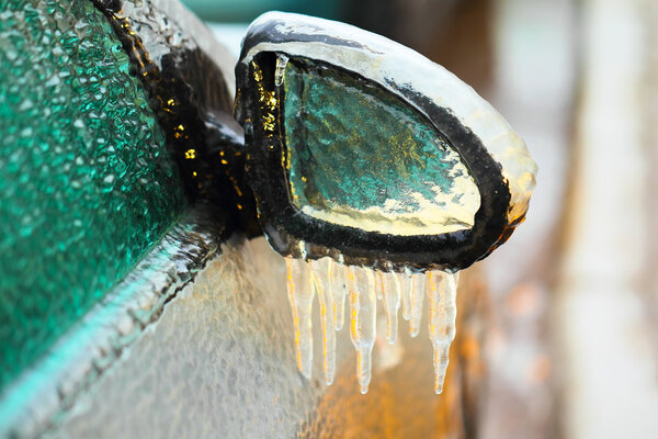 Car side mirror covered with ice