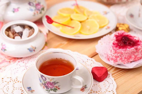 Taza caliente de té, limón y dulces — Foto de Stock