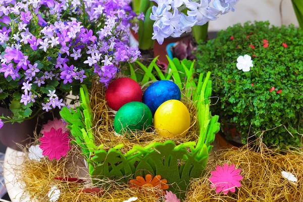 Doğal bir saman içinde dört renkli Paskalya yumurtaları — Stok fotoğraf