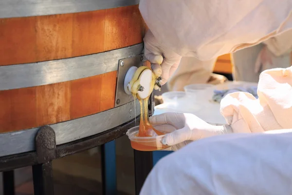 Mann schüttet Honig aus der Tonne — Stockfoto