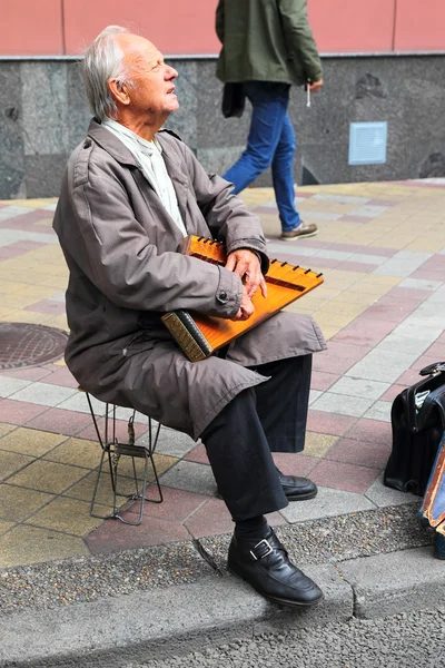 Oude man met de muzikale instrument gusli — Stockfoto