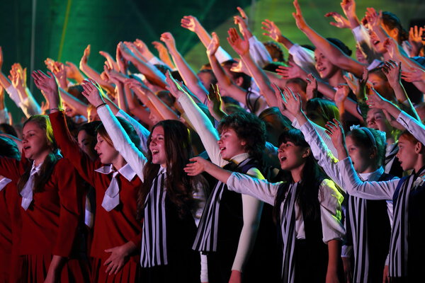 Large group of happy teens sings together