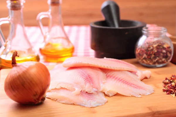 Çiğ balık tilapia kesme tahtası ve baharatlar — Stok fotoğraf