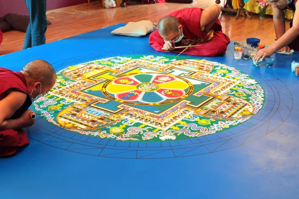 Tibetische Mönche bauen Mandala aus farbigem Sand — Stockfoto