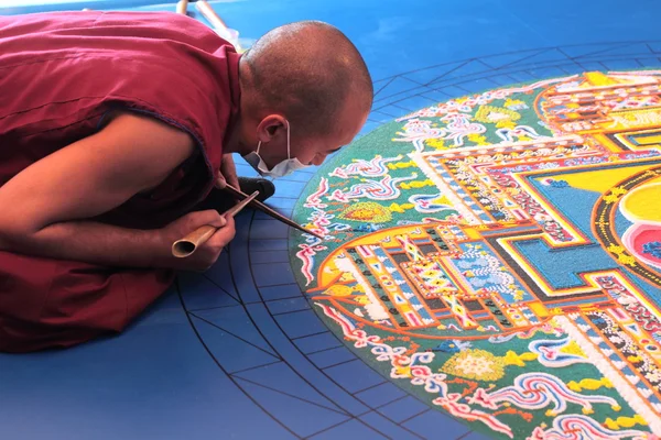 Tibetische Mönche bauen Mandala aus farbigem Sand lizenzfreie Stockfotos