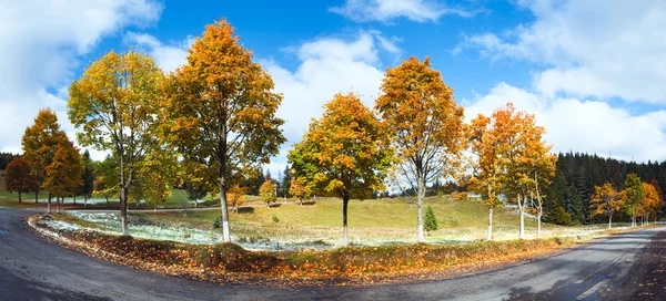 Primera nieve de invierno y árboles coloridos de otoño cerca del camino de montaña — Foto de Stock