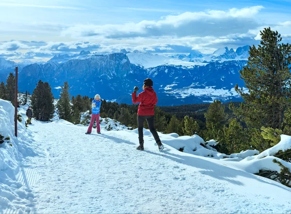 Famiglia gioca a palle di neve sul pendio di montagna invernale — Foto Stock