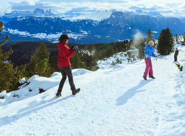 Familia juega en bolas de nieve en la pendiente de la montaña de invierno — Foto de Stock