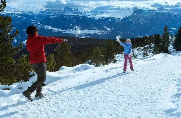 Família joga em bolas de neve na encosta da montanha de inverno — Fotografia de Stock