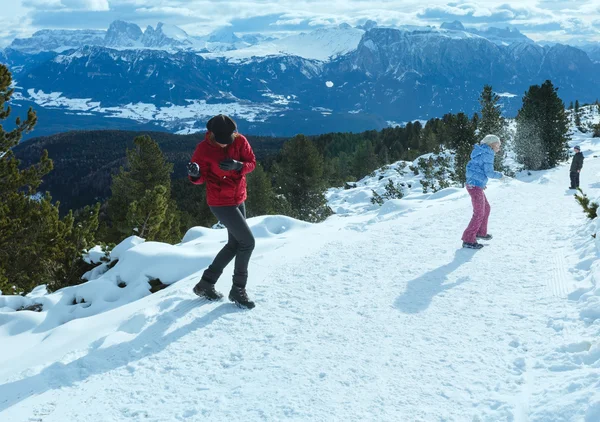 Famiglia gioca a palle di neve sul pendio di montagna invernale — Foto Stock