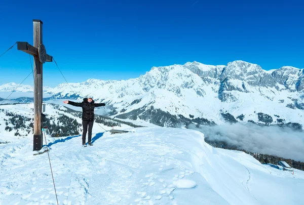 Turista perto da cruz no topo da montanha de inverno — Fotografia de Stock