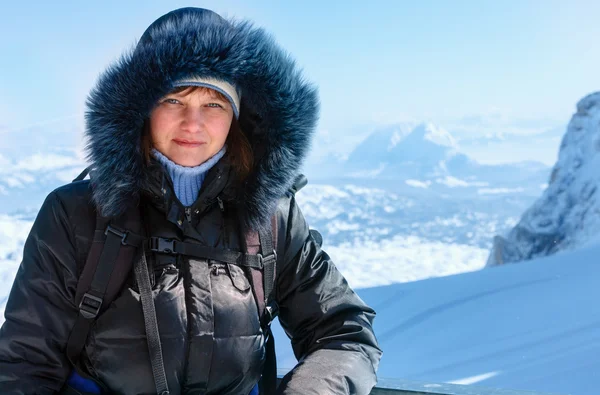 Vrouw op winter berg achtergrond (Oostenrijk). — Stockfoto