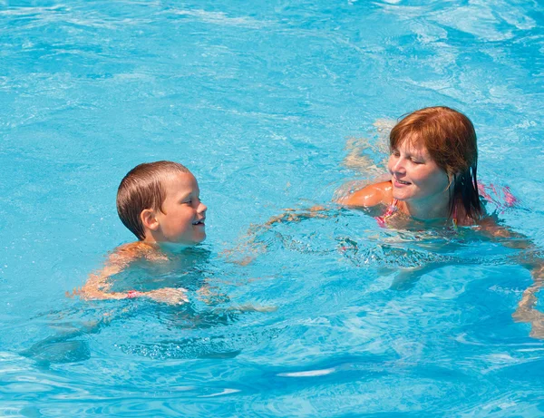 Madre entrenar a su hijo a nadar en la piscina . —  Fotos de Stock