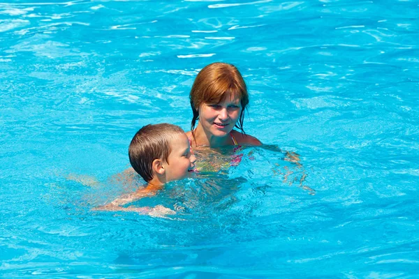 Mutter trainiert ihren Sohn zum Schwimmen im Pool. — Stockfoto