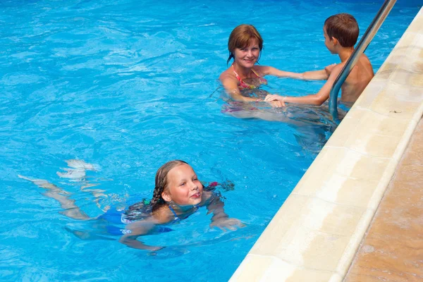 Mutter schult Kinder zum Schwimmen im Pool. — Stockfoto