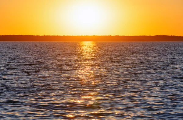 Solnedgång och solen spår på sjön yta. — Stockfoto