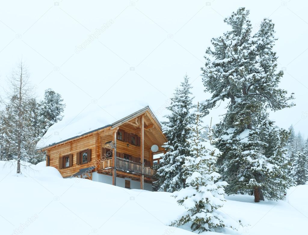 wood house in winter misty mountain