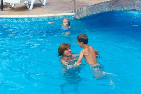 Mutter schult Kinder zum Schwimmen im Pool. — Stockfoto