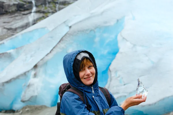 Frau mit Eisstück nahe Nigardsbreen-Gletscher (Norwegen)) — Stockfoto