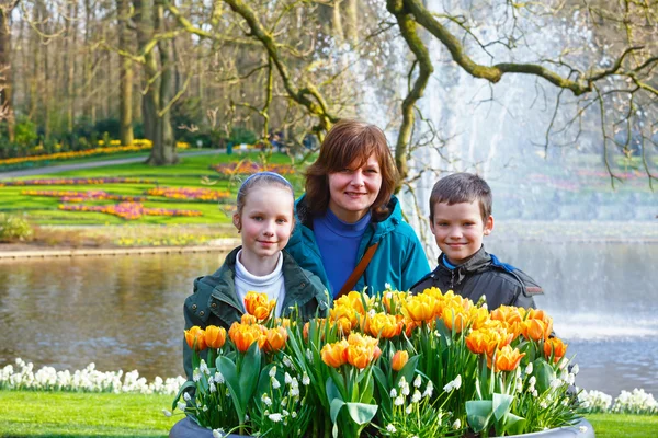 Gelukkige familie met gele tulpen. — Stockfoto