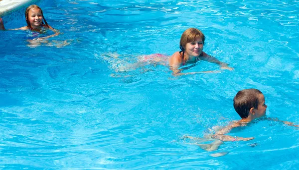 Mutter schult Kinder zum Schwimmen im Pool. — Stockfoto