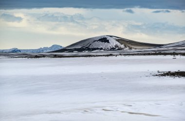 Sonbaharda İzlanda 'da kar altında renkli Landmannalaugar dağları. Önplanda volkanik kumdan oluşan lav alanları.