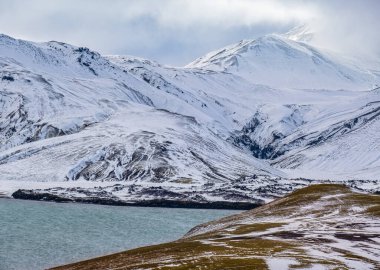 Güney İzlanda 'da mevsim değişiyor. Sonbaharda kar altında renkli Landmannalaugar dağları. Dağın eteğindeki Frostastadavatn Gölü.