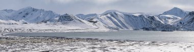 Güney İzlanda 'da mevsim değişiyor. Sonbaharda kar altında renkli Landmannalaugar dağları. Dağın eteğindeki Frostastadavatn Gölü.