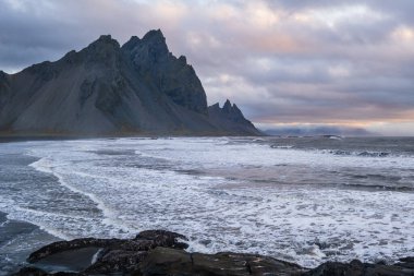 Sunrise Stoksnes Cape Deniz Sahili ve Vestrahorn Dağı ve okyanus sörfü. İnanılmaz doğa manzarası, popüler seyahat merkezi..
