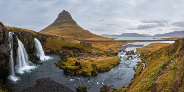 Famous picturesque Kirkjufell mountain and Kirkjufellsfoss waterfall next to Grundarfjordur, West Iceland autumn view.
