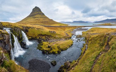 Famous picturesque Kirkjufell mountain and Kirkjufellsfoss waterfall next to Grundarfjordur, West Iceland autumn view.
