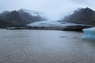 Güney İzlanda, Vik yakınlarındaki Reynisfjara plajında bazalt kaya sütunları. Eşsiz jeolojik volkanik oluşumlar. Reynisfjall Dağı eteğinde bir mağara..      