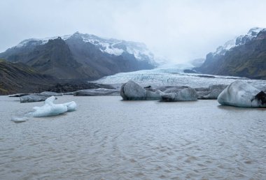 Güney İzlanda, Vik yakınlarındaki Reynisfjara plajında bazalt kaya sütunları. Eşsiz jeolojik volkanik oluşumlar. Reynisfjall Dağı eteğinde bir mağara..      