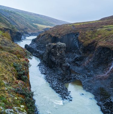 Sonbahar resimli Studlagil Kanyonu, Doğu İzlanda 'nın Jkuldalur şehrinde bir vadidir. Ünlü sütun bazalt kaya oluşumları ve Jkla nehri boyunca akar..