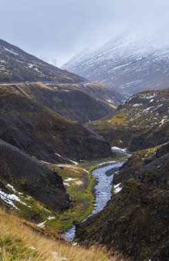 İzlanda 'nın kuzeyinde sonbahar bulutlu bir gün. Güzel kanyondan akan küçük bir nehir.