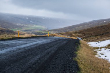 İzlanda 'da otomobil gezisi sırasında çakıl yolu ve dağ manzarası. İzlanda manzaralı muhteşem sonbahar manzarası..