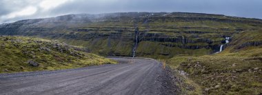 İzlanda 'da otomobil gezisi sırasında çakıl yolu ve dağ manzarası. İzlanda manzaralı muhteşem sonbahar manzarası..