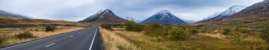 İzlanda 'da otomobil gezisi sırasında otoyol ve dağ manzarası. Manzaralı İzlanda manzarası: fiyortlar, tarlalar, bulutlar, buzullar, şelaleler.