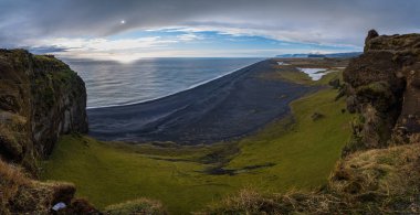 Dyrholaey Cape Viewpoint, Vik, Güney İzlanda 'dan sonsuz okyanus siyah volkanik kumsal manzarası. İnsanlar tanınmaz halde..