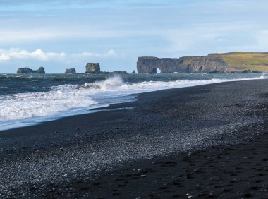 Resimli sonbahar Dyrholaey Burnu ve Reynisfjara okyanus siyah volkanik kumsal manzaralı kaya oluşumları. Vik, Güney İzlanda.